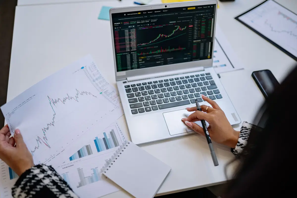 Financial charts on paper and on a laptop screen during a business review